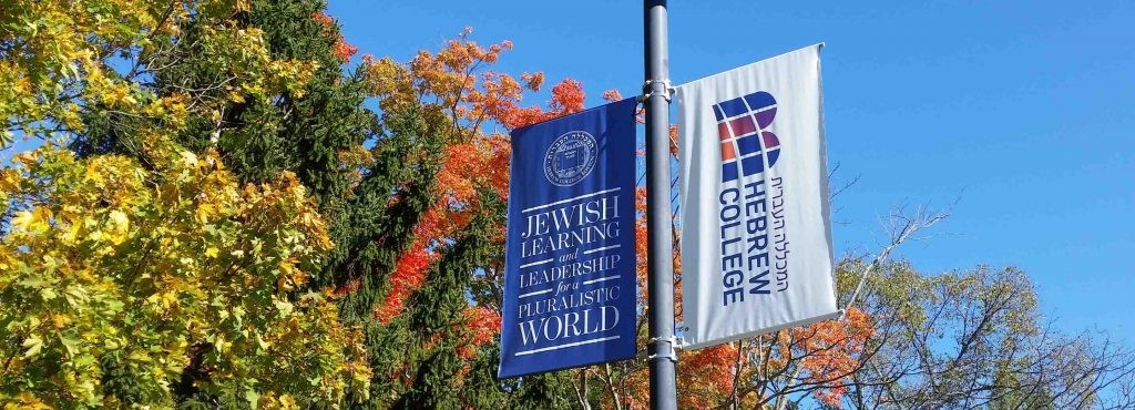 Two flags, Hebrew College's name and logo.  Fall leaves in the background.