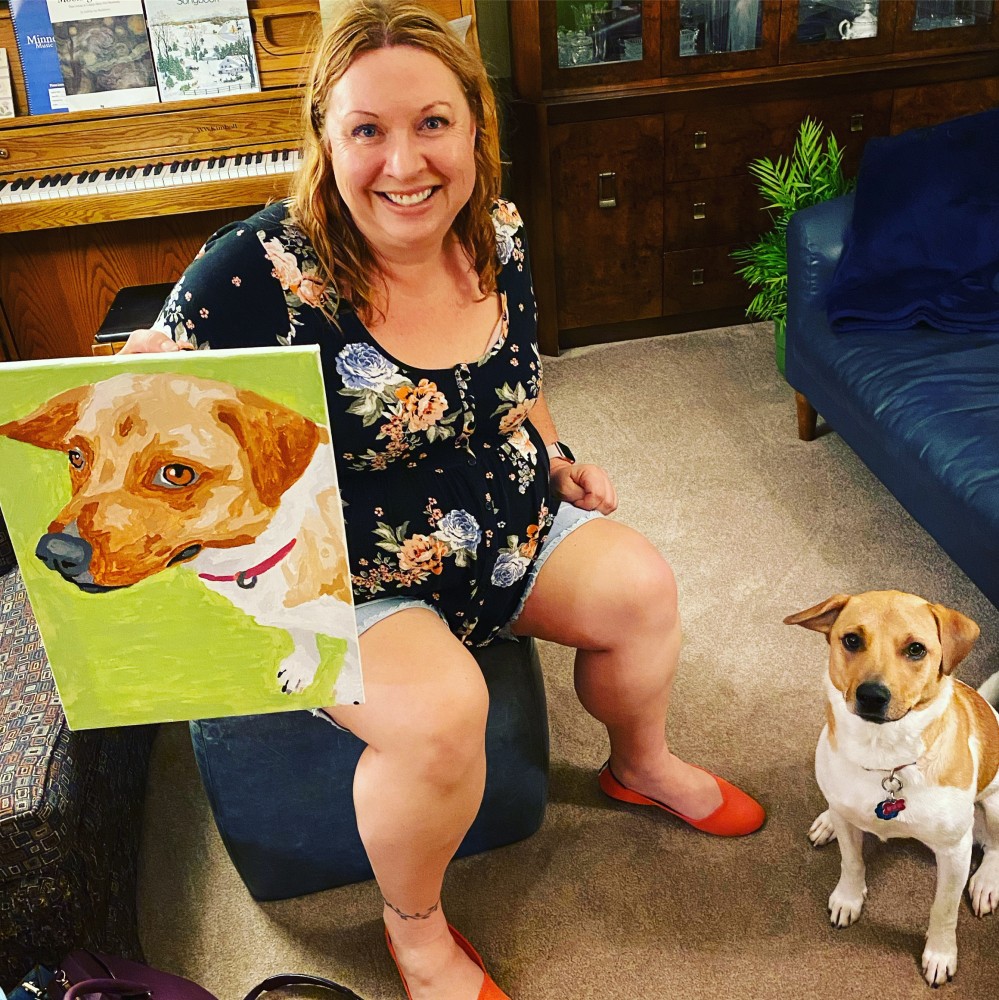Photo of the author with her dog and a paint-by-number picture of the dog.